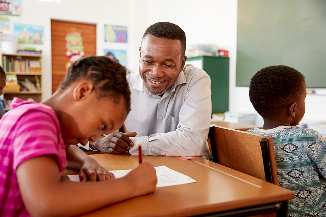 Teacher supporting pupils at their desks